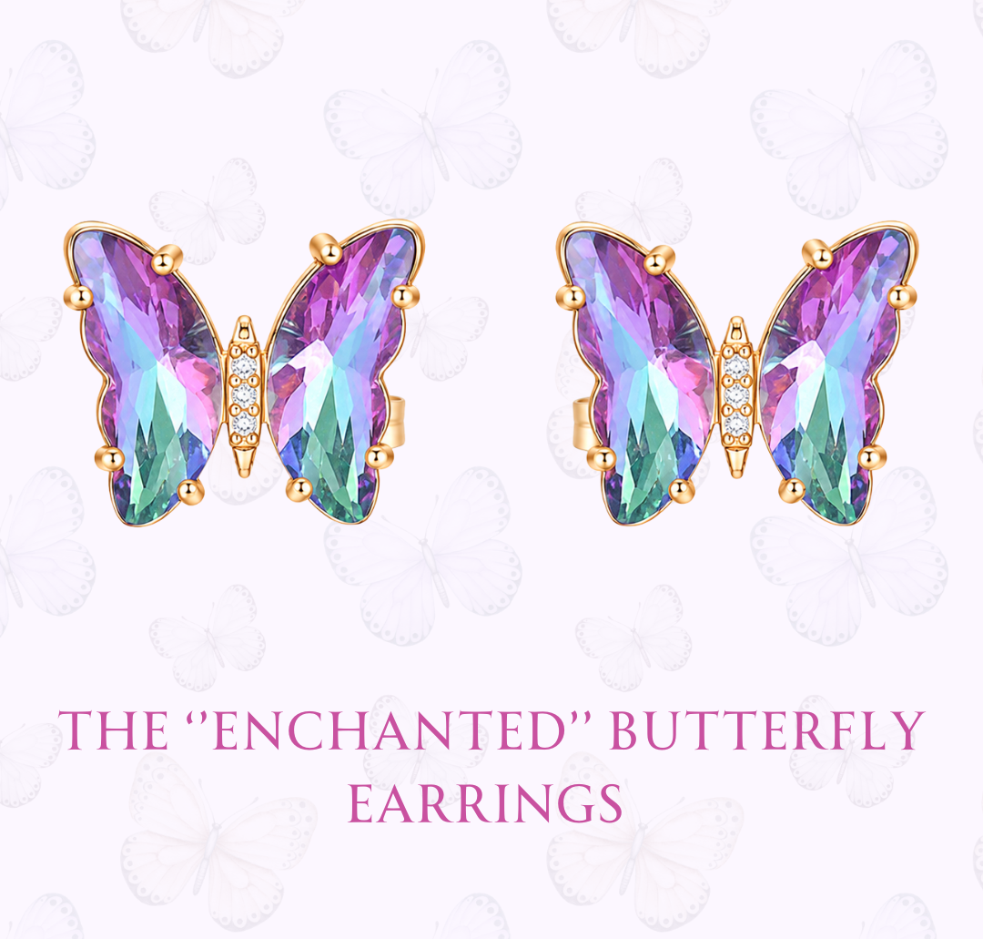 A pair of butterfly-shaped stud earrings with iridescent purple, pink, and green faceted stones in gold settings, shown on a pale pink background with decorative butterfly outlines and the text 'THE "ENCHANTED" BUTTERFLY EARRINGS' and 'www.hebejewel.