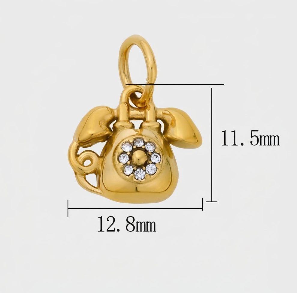 A gold charm shaped like a rotary telephone, shown on a light gray background with dimension lines and measurements indicating 12.8mm width, 11.