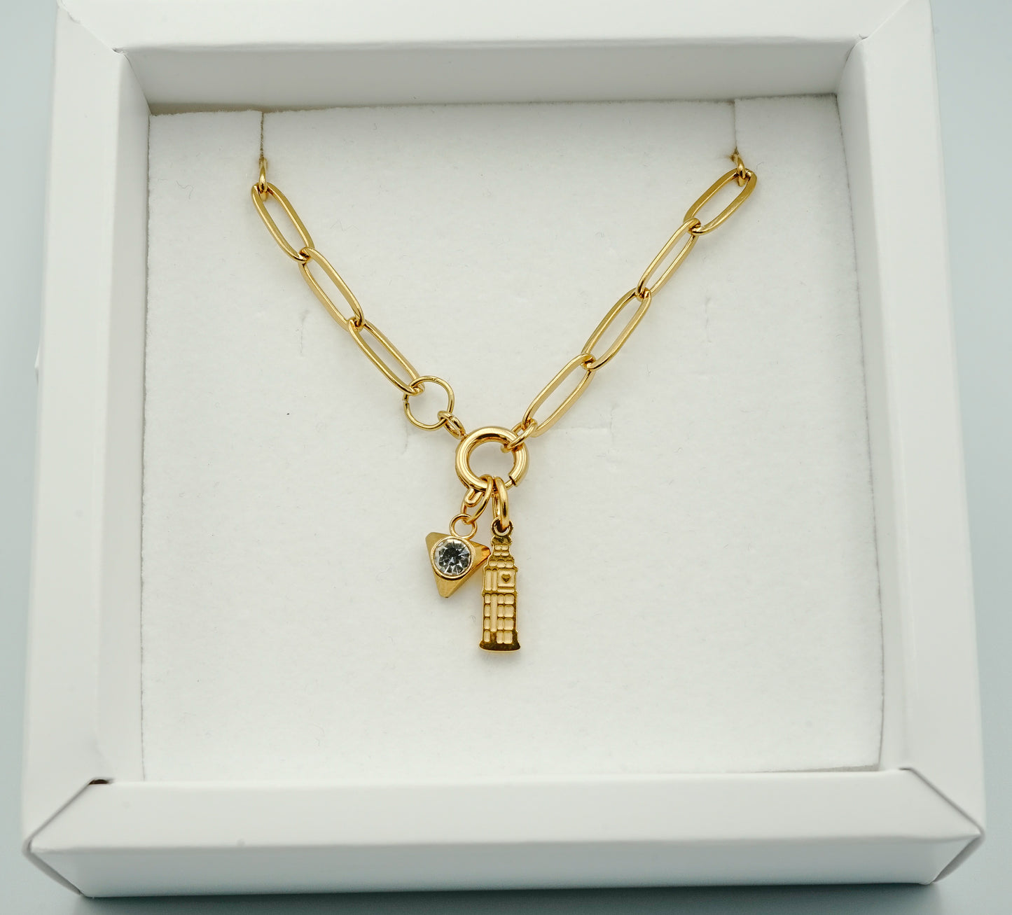 Gold necklace with charms in a white box