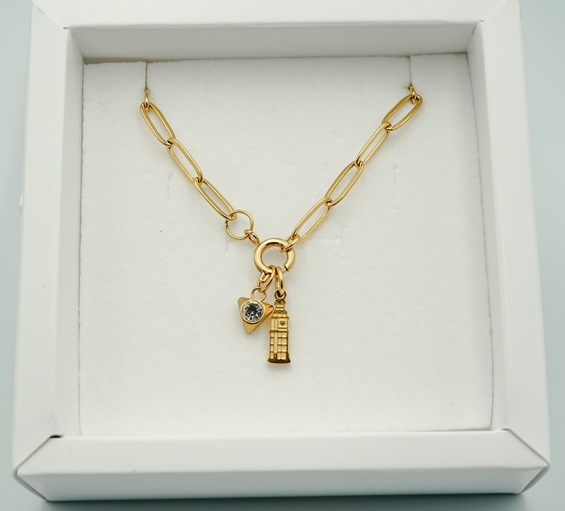 Gold necklace with charms in a white box