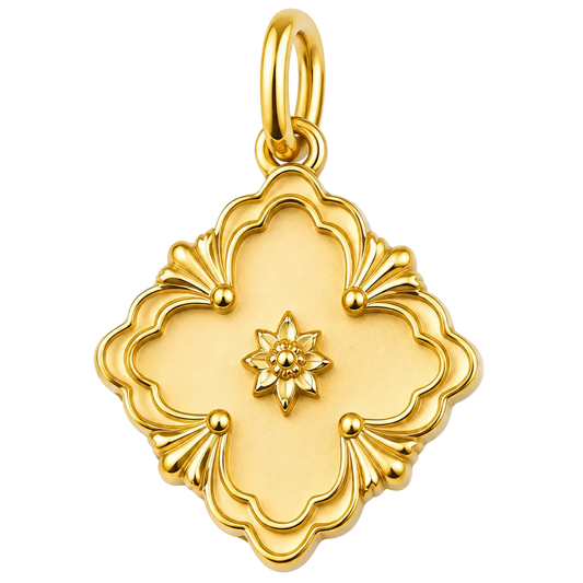 A gold pendant charm with a decorative quatrefoil design and a small star motif in the center, shown on a plain white background.