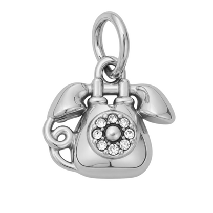 A polished silver charm shaped like a vintage rotary telephone, featuring a circular halo of clear rhinestones on the face. The charm is displayed on a clean white background with a green 'NEW ARRIVAL' banner in the top-left corner.