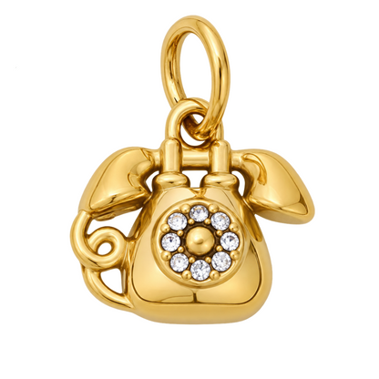 A polished yellow gold charm shaped like a vintage rotary telephone, featuring a circular arrangement of clear rhinestones on the face. The charm is shown on a clean white background with a green 'NEW ARRIVAL' banner in the top-left corner.