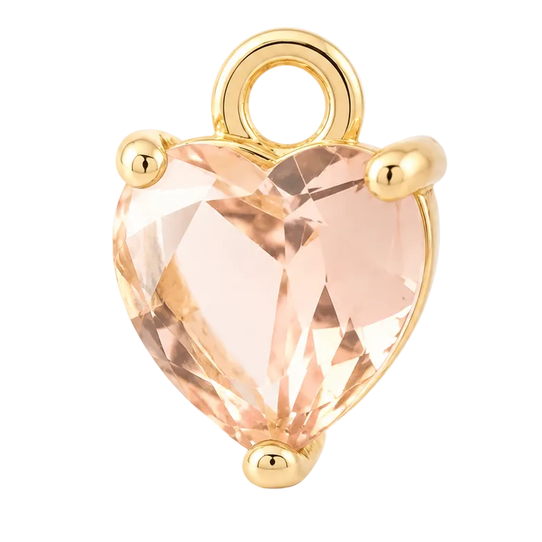 A heart-shaped faceted peach crystal pendant charm set in a gold-tone metal prong setting with a top loop, shown on a clean white background.