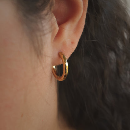 woman wearing minimal golden earrings